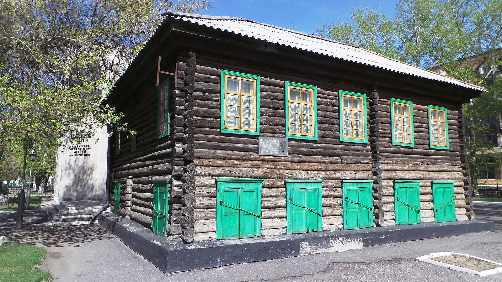 A log-house-style cabin with green details. 