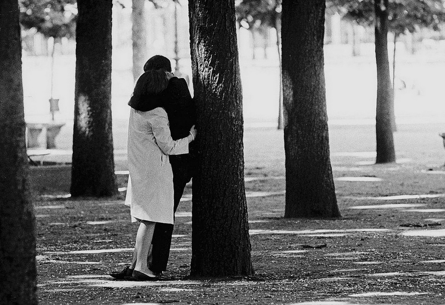 A man and a woman holding each other in a park