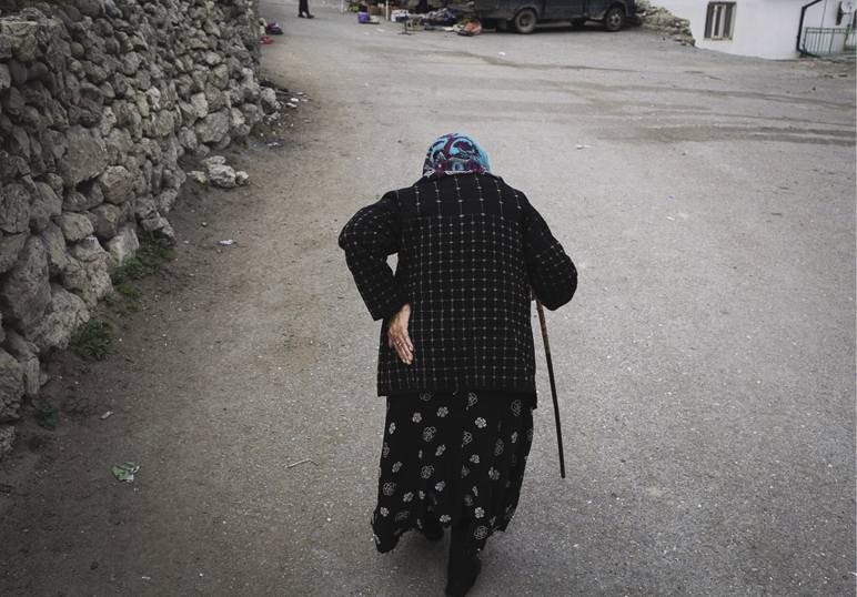Old woman walking down street.