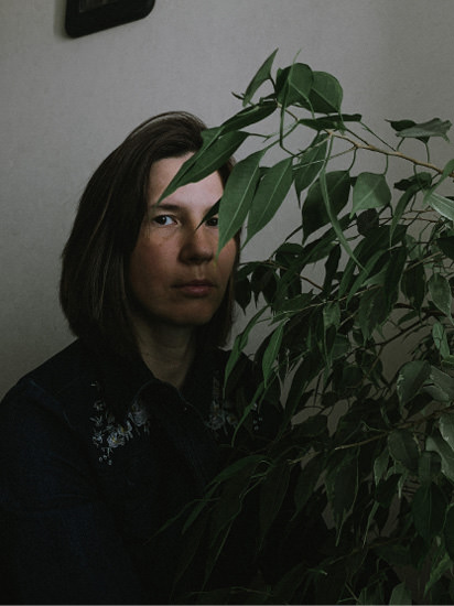 Woman standing with plants.