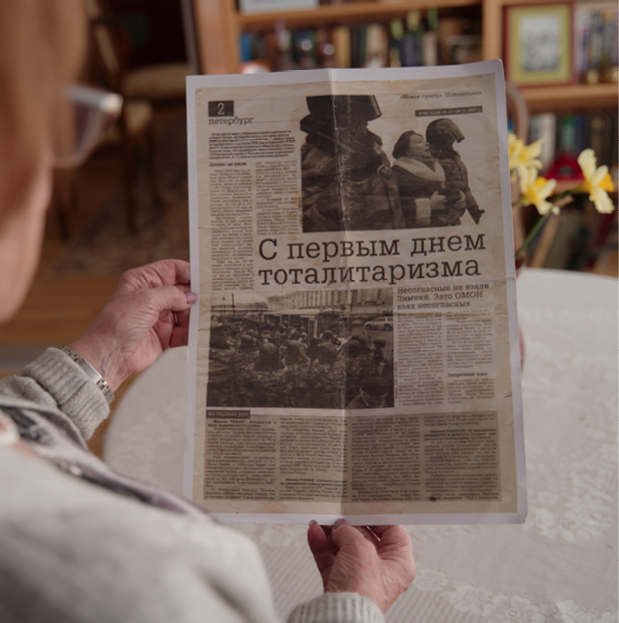 Woman holding newspaper clipping.