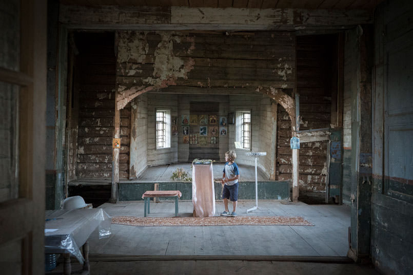 Boy inside falling down church.