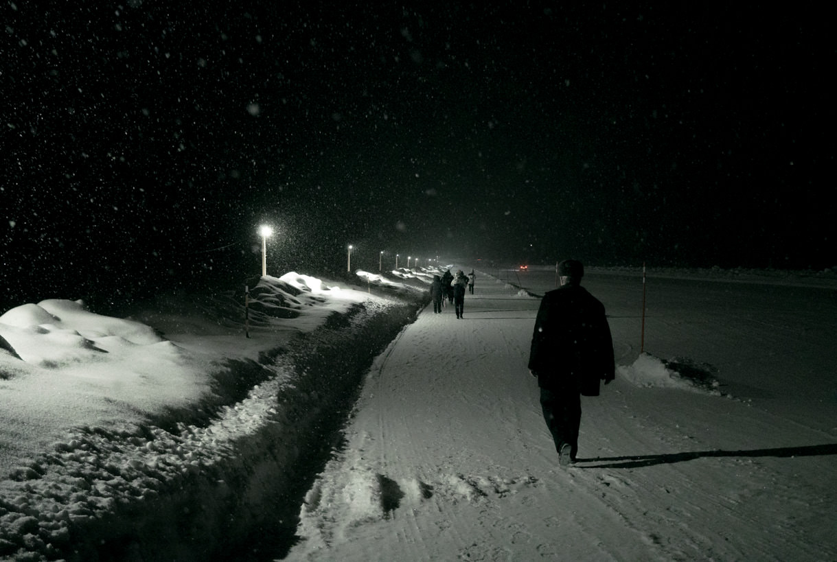 Man crossing a snowy river at night.