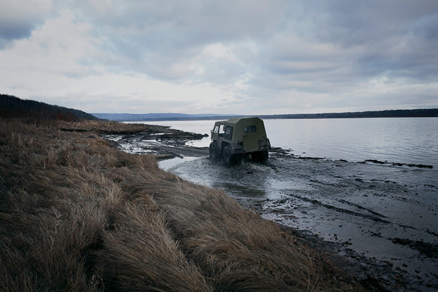 Truck traveling over beach.