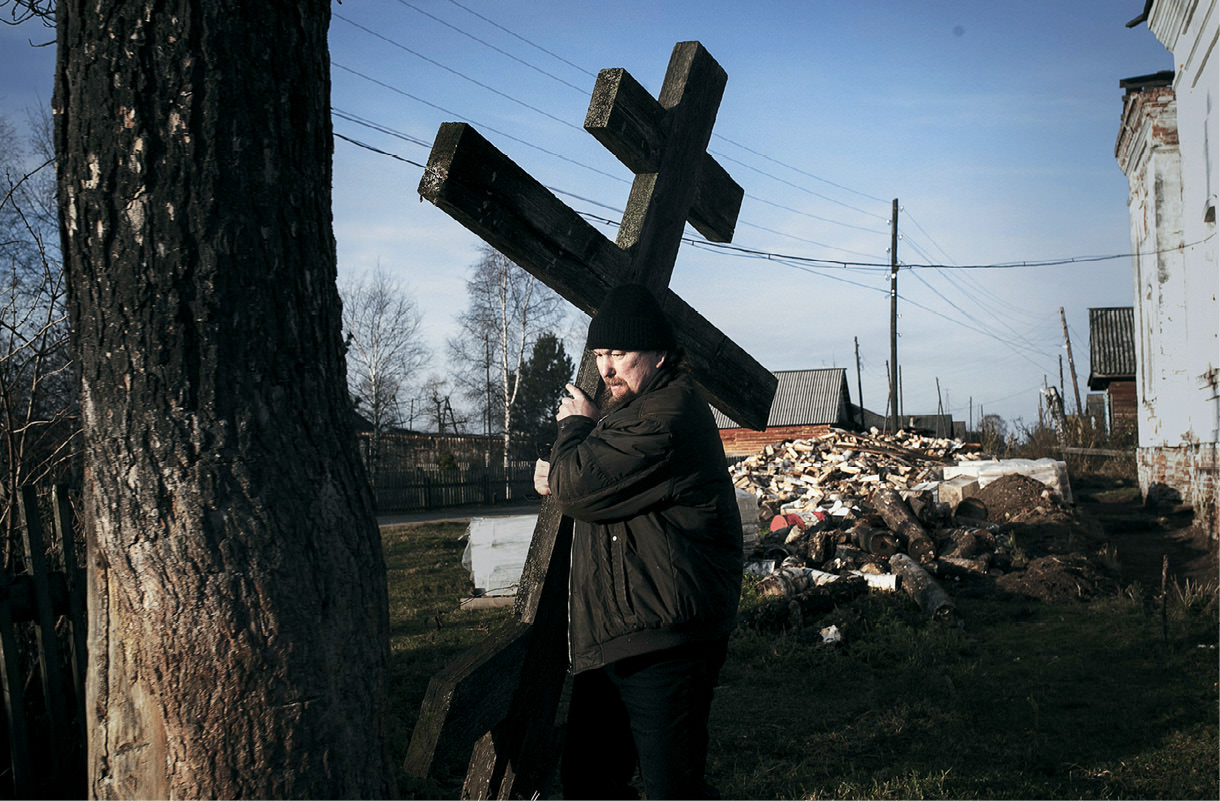 Priest carrying a cross.