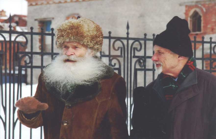 Two men speaking outdoors in winter.