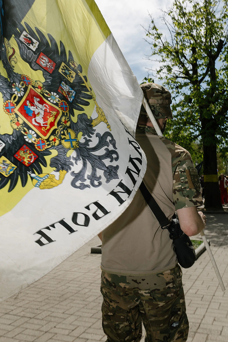 Man carrying imperial Russian flag.