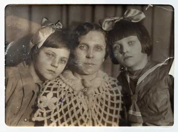 Mother and her daughters looking at camera.